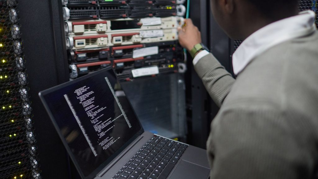 サーバーラックを保守する人物とノートPC（イメージ）